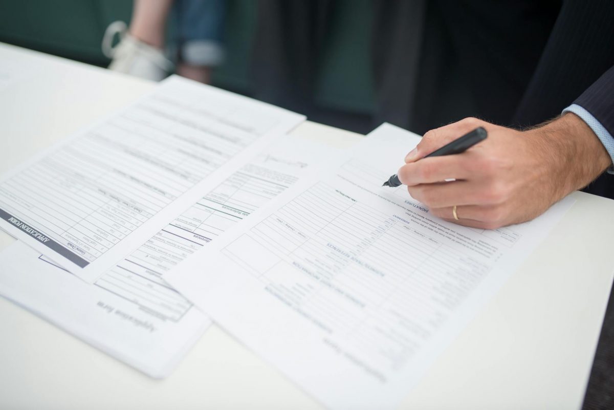 Expat couple reviewing Rechtsschutzversicherung documents in Germany, understanding German legal rights.
